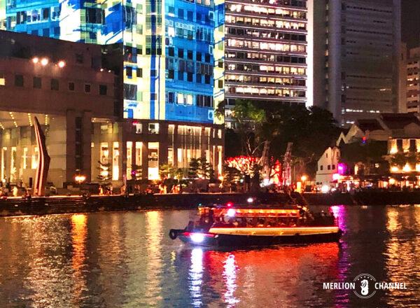 River Cruise passing by the skyscrapers of Boat Quay